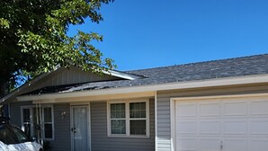 A residential house with a garage, a driveway, and a parked car. - Nice 3-bedroom house with AC in peaceful Lubbock neighborhood (Lubbock)