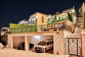 Ein mehrstöckiges Gebäude mit überdachtem Parkhaus und einem befahrbaren, begrenzten Eingangsbereich.