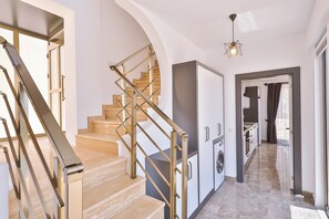 Ein modernes Interieur mit Treppe, Küche und Waschbereich.