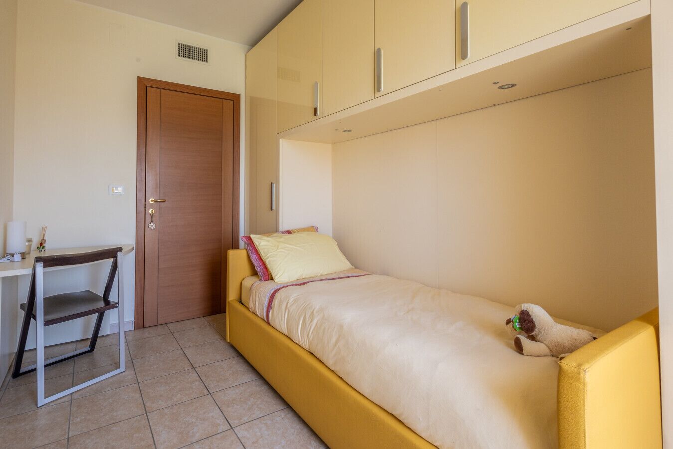A small room with a bed, a desk, and a chair.