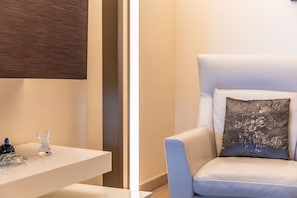 Ein modernes Zimmer mit einem weißen Stuhl, einem kleinen Tisch und einem Zierkissen.