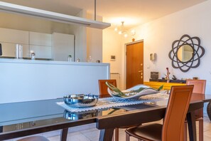 Una cucina moderna con un tavolo da pranzo in vetro, sedie e una ciotola decorativa.