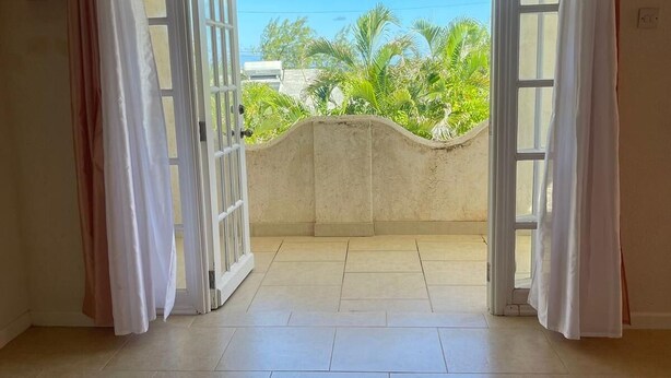 An open balcony with a view of greenery and buildings. - 2-bedroom townhome in tranquil Belair with cool Atlantic breeze (Belair)