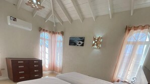 A bedroom with two beds, a dresser, a window with curtains, and a ceiling fan. - 2-bedroom townhome in tranquil Belair with cool Atlantic breeze (Belair)