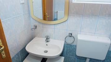 Une salle de bain avec un lavabo, des toilettes et un miroir.