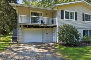 Une maison à deux étages avec un porche avant couvert, un garage et une boîte aux lettres.