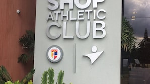 Un letrero para el Body Shop Athletic Club, con un logotipo y una figura humana estilizada.