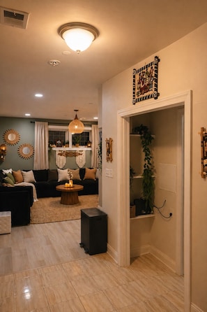 A living room with a sofa, coffee table, and decorative items. There is a door leading to another room. - zy Boho Suite in Takoma, Private Entry, Parking (Washington)