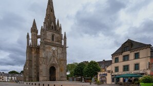 A historic cathedral with a clock tower, a cobblestone square, and a building with a sign for 'Hotel de l'Industrie.' - Guest Room "La chambre loft" in Modern Loft with Shared Terrace and Wi-Fi in Hennebont (Hennebont)