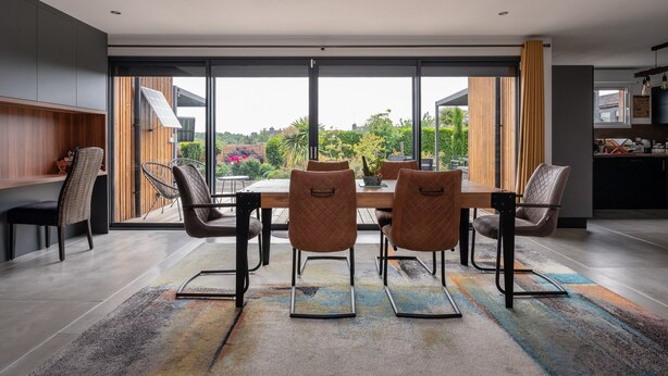 A modern dining area with a large table, six chairs, and a view of greenery through large windows. - Guest Room "La chambre loft" in Modern Loft with Shared Terrace and Wi-Fi in Hennebont (Hennebont)
