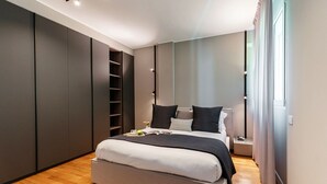 Un dormitorio moderno con una cama grande, estanterías integradas y vistas al exterior.