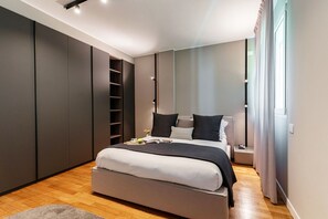 Ein modernes Schlafzimmer mit einem großen Bett, integrierten Regalen und Blick ins Freie.