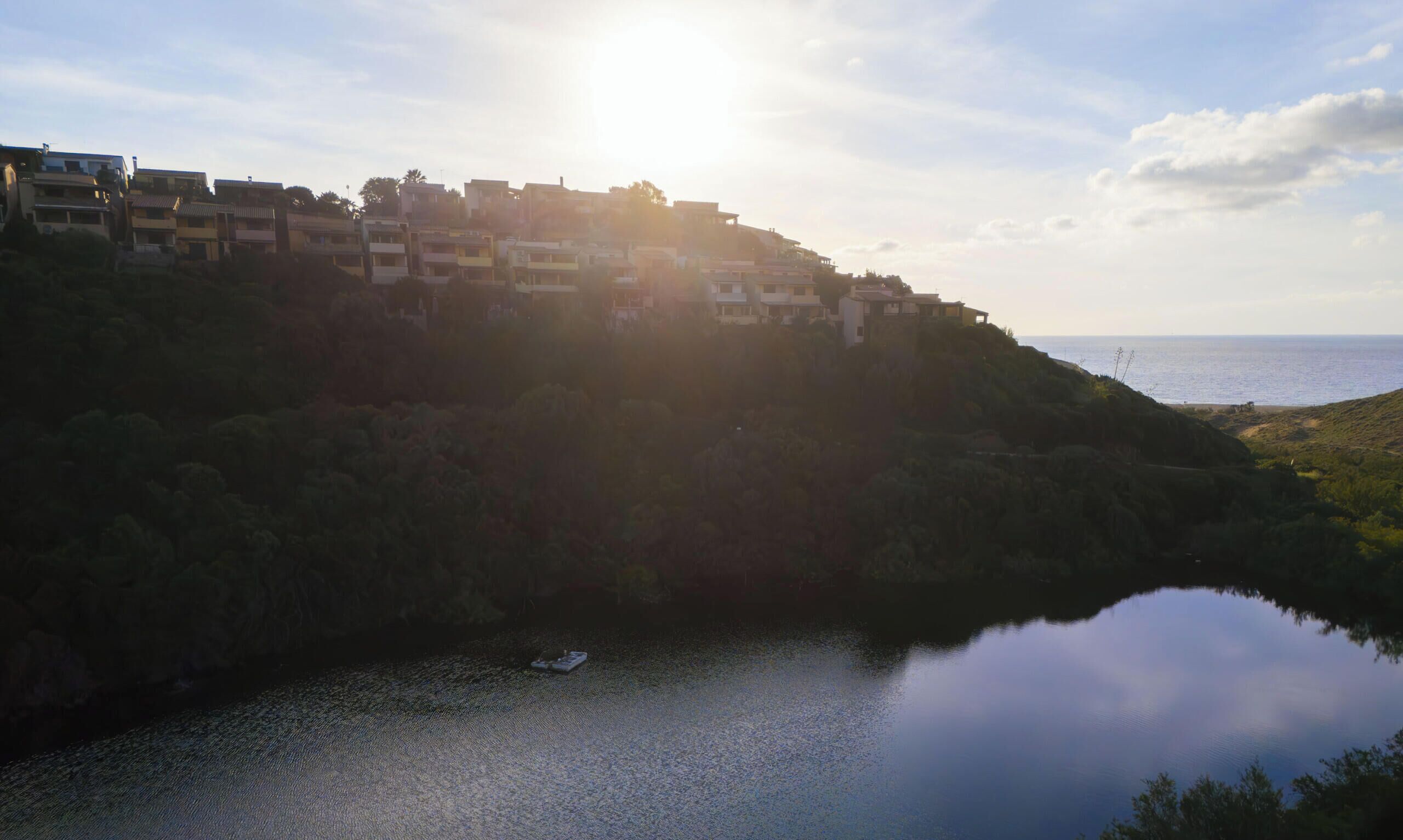 Une ville côtière avec des bâtiments construits sur une colline, surplombant une étendue d’eau calme.