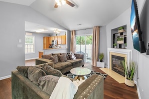A living room with a sectional sofa, a fireplace, and a television.
