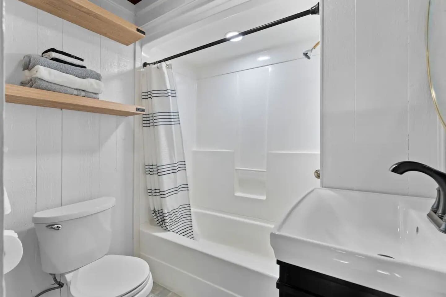 Une salle de bain comprenant des toilettes, une baignoire avec un rideau de douche et un lavabo.