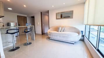 Apartamento Deluxe, vistas a la ciudad | Zona de estar | Televisor de 60 pulgadas con canales digitales