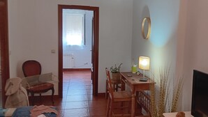 A room with a wooden dining table, chairs, a lamp, a TV, and a door leading to another room. - Apartment 'Garro1' with Mountain Views (Donostia / San Sebastián)