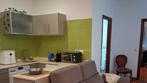 A living room with a sofa, a microwave, a kettle, and a small table. - Apartment 'Garro1' with Mountain Views (Donostia / San Sebastián)