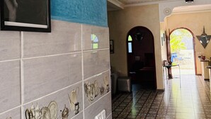 Un pasillo con baldosas estampadas, un cuadro en la pared y un techo decorativo.