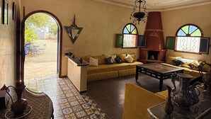 Una sala de estar con un sofá, una mesa de centro, un televisor y una chimenea.