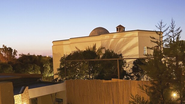Una casa moderna con un amplio patio, piscina y jardín cuidado.