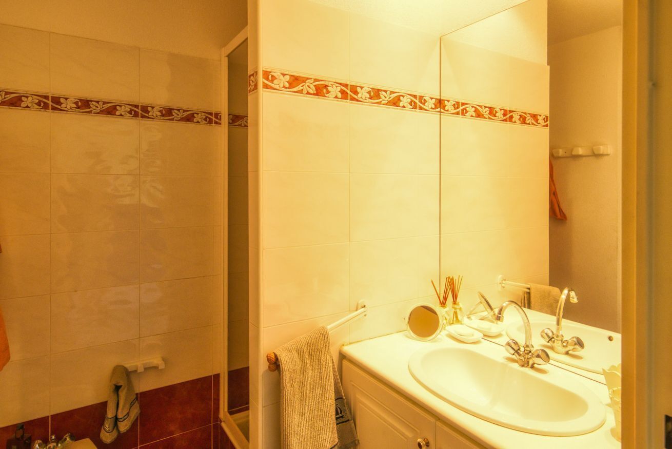 Een douche, een bidet, handdoeken, toiletpapier