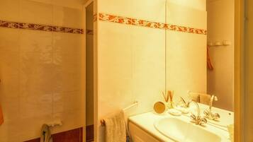 Een douche, een bidet, handdoeken, toiletpapier