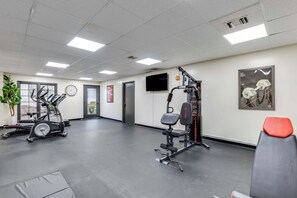 A gym with treadmills, weight machines, and a wall-mounted TV. - One Bedroom, First Floor (Wichita)