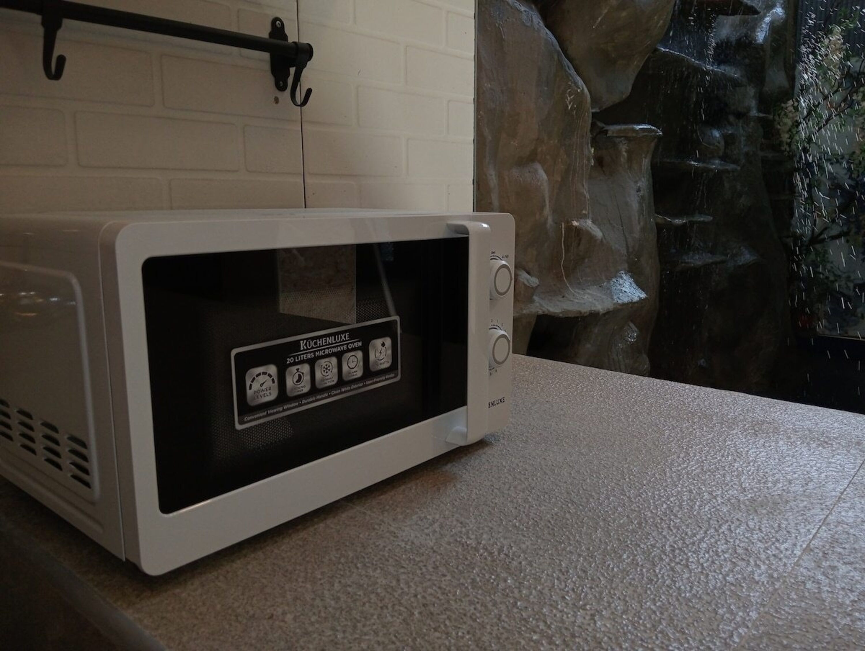 A white microwave oven with a digital display and control buttons, placed on a countertop.
