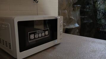 A white microwave oven with a digital display and control buttons, placed on a countertop.