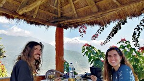 Two people dining at a table with a view of mountains.