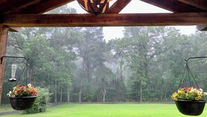 A wooden structure with a hanging light fixture and two hanging flower pots. - Charming Country Get-away! Pet Friendly (Fairview)