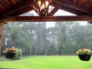 A wooden structure with a hanging light fixture and two hanging flower pots.
