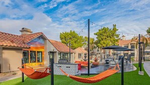 Un quartiere residenziale con case, un'amaca, mobili da giardino e una piscina.