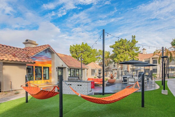A residential area with houses, a patio with outdoor furniture, and a hammock.