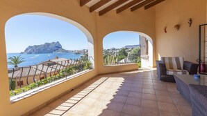 A balcony with a view of the sea and a mountain, furnished with a sofa and a table. - Villa Wioleta - Costa CarpeDiem (Benissa, Alicante)