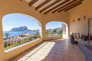 A balcony with a view of the sea and a mountain, furnished with a sofa and a table. - Villa Wioleta - Costa CarpeDiem (Benissa, Alicante)