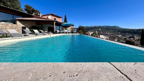 A swimming pool with lounge chairs, a stone wall, and a view of a town and hills. - 🌴 SPECIAL SUMMER CLOSING SALE: 30% off from August 22 to August 29 🌴 (Ollioules)