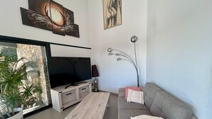 A modern living room with a flat-screen TV, a wooden coffee table, a grey sofa with pink cushions, and a floor lamp. - 🌴 SPECIAL SUMMER CLOSING SALE: 30% off from August 22 to August 29 🌴 (Ollioules)