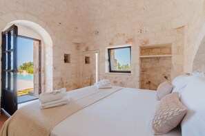 A bedroom with a bed, a window, and a door leading to a balcony. - Tenuta Romance by Perle di Puglia (Carovigno)