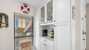 A kitchen with white cabinets, a coffee maker, and a view through a window with blinds. - 5 Minutes to the beach!
Beautiful 2-bedroom Condo in St Pete (St. Petersburg)