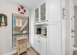 A kitchen with white cabinets, a coffee maker, and a view through a window with blinds. - 5 Minutes to the beach!
Beautiful 2-bedroom Condo in St Pete (St. Petersburg)