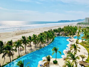 A resort with a swimming pool, beach, and palm trees. - Exclusive, unparalleled view, La Isla Residences Acapulco (Acapulco de Juárez)