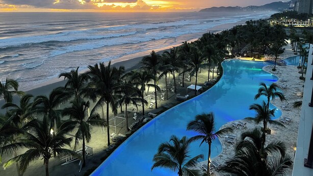 Un complex turístic amb piscina, platja i vista a l'oceà.
