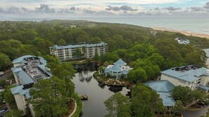 Een resort met meerdere gebouwen, een centraal waterpartij en uitzicht op het strand.