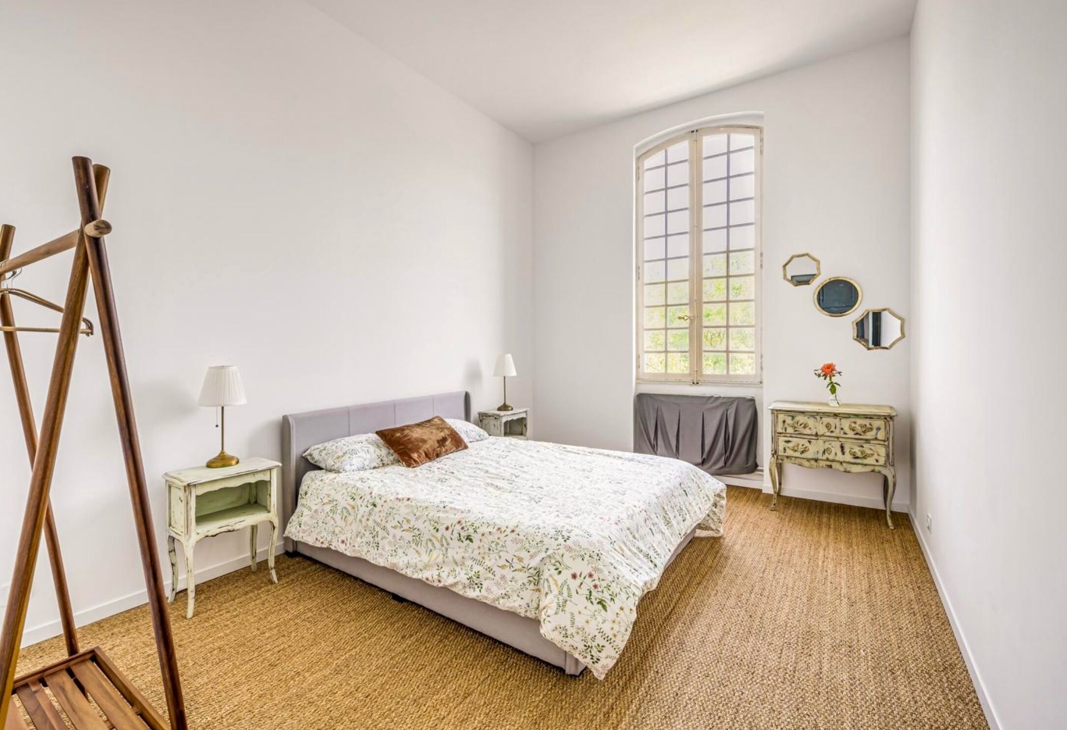 Un dormitorio con cama, ventana, cómoda y lámpara.