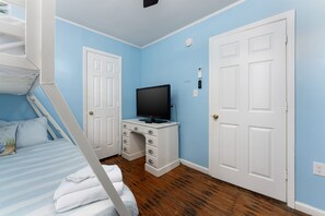 A bedroom with a bunk bed, a desk with a television, and two white doors. - 710 Canal Lower - Make Everyday a Holiday! (Carolina Beach)
