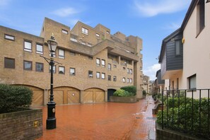 A brick building with multiple windows and a gated entrance. - Spacious 2-bed Near Tower Bridge Canary Wharf (London)