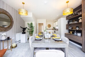 A dining area with a marble table, yellow napkins, and a mirror on the wall. - Spacious Stylish 3-bedroom Home With Free Parking in Sw17 (London)