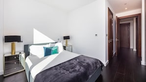 Un dormitorio moderno con cama, mesitas de noche y un armario.
